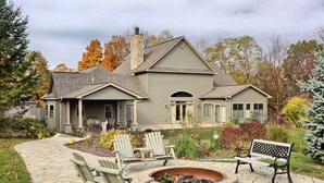 A two-story house with a stone chimney, a covered porch, and a fire pit in the front yard. - Shamrock- Aunt Susie's- Raystown Lake- 7 Points (Hesston)