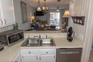 La cuisine est Ă©quipĂ©e dâun four Ă micro-ondes, dâun Ă©vier Ă deux bacs et dâun lave-vaisselle. On y trouve Ă©galement un coin repas avec une table et des chaises, ainsi quâun salon avec un canapĂ© et un tĂ©lĂ©viseur.