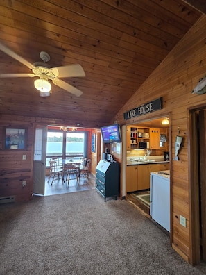 A cabin interior with a dining area, kitchen, and a sign reading 'LAKE HOUSE.' - Cozy 2 Bedroom LAKE FRONT Cabin on Chetek Chain of Lakes, GREAT LOT & LOCATION! (Chetek)
