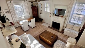 Un salón espacioso con chimenea, zona de comedor y escalera que sube a un piso superior.