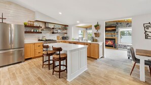 A spacious kitchen with a central island, wooden cabinets, and a built-in microwave. - Lakeside Retreat- 7beds/4bd/2ba! Family and pet friendly!  (Zimmerman)