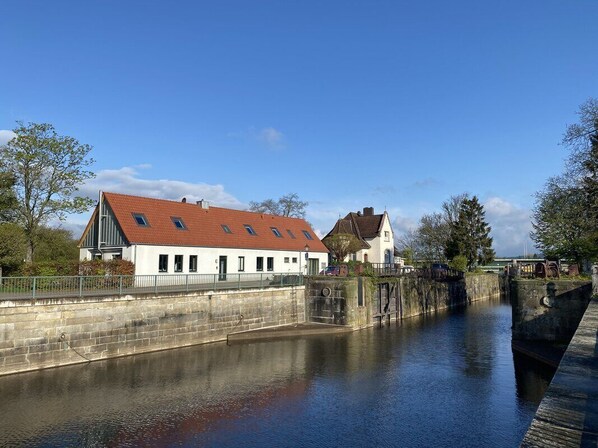 A canal with a stone bridge and buildings on the opposite bank. - Luxus Loft im Schleusenhaus auf der Insel in Hameln (Hameln)
