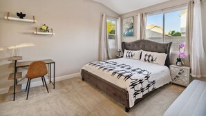 Un dormitorio con cama, escritorio y silla.