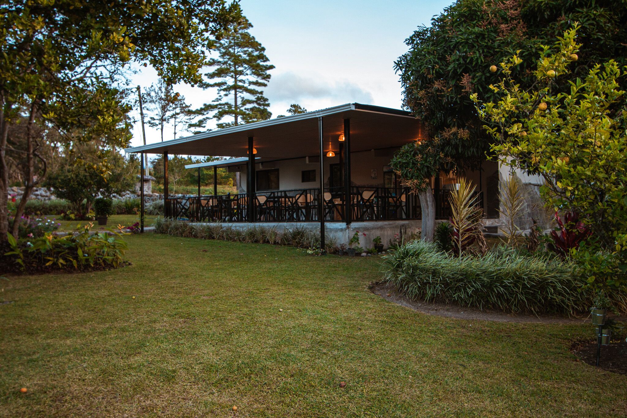 A building with a covered patio area, surrounded by well-maintained landscaping and trees.