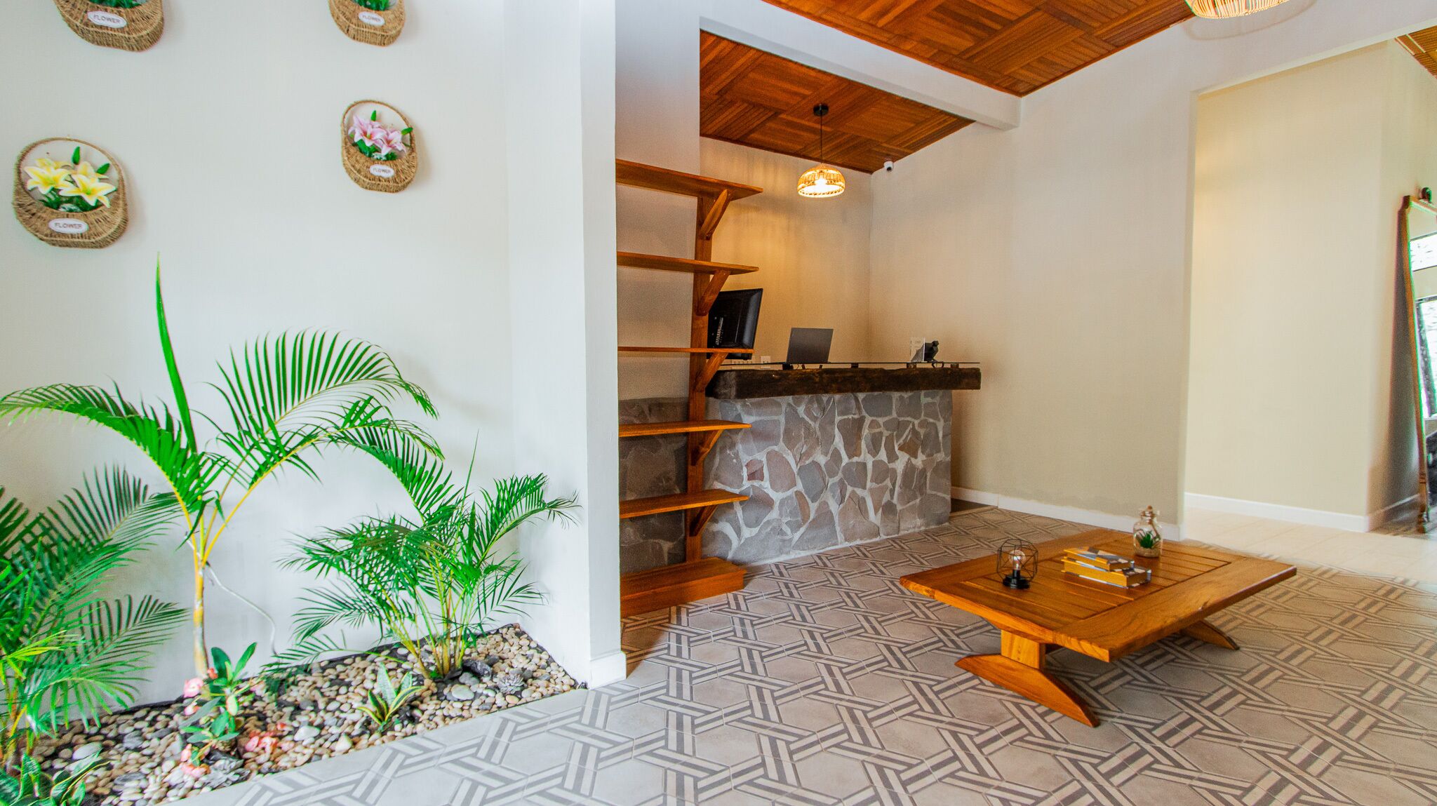 A reception area with a stone fireplace, wooden shelves, a wooden coffee table, and a potted plant.