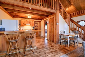 Un intérieur en bois comprenant une cuisine, un coin repas et un escalier.