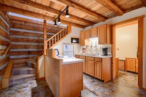 A wooden interior with a kitchen area, a built-in island, and a staircase. - Navajo in Hocking Hills (Logan)