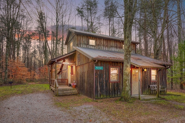 A rustic cabin with a porch, a small attached shed, and a sign reading "Navajo."