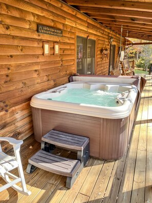 A wooden cabin with a hot tub, a wooden deck, and a sign that reads "In our family we don't go crazy, we put on a great beer!" - Dewdrop Inn in Hocking Hills (Logan)