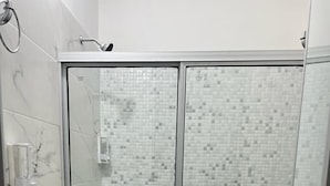 A bathroom with a glass-enclosed shower, a white toilet, and a white sink. - COOL HOUSE (Arauca)