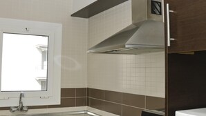 A kitchen with a stainless steel sink, a window, and a range hood. - APCOSTAS Tropik / Two Bedrooms (L'Estartit)