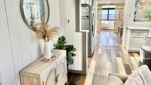 A modern kitchen with white cabinets, a wooden countertop, and a built-in oven. - Pet Friendly • Sleeps 8 • West PCB (Panama City Beach)