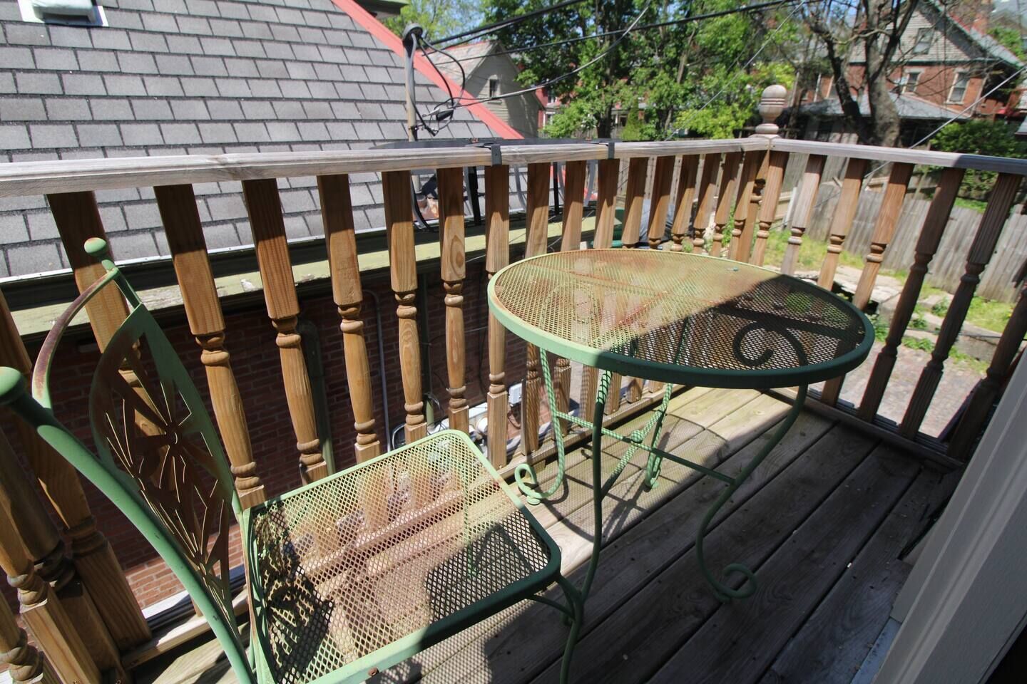 A wooden deck with a metal table and chair.
