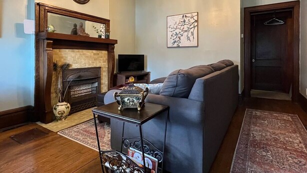 A living room with a fireplace, a sofa, a coffee table, and a television.