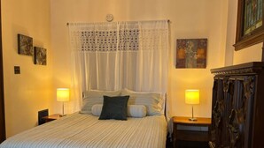 A neatly made bed with a striped bedspread, two bedside lamps, and a wooden nightstand.