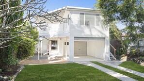 A two-story residential house with a garage, a covered porch, and a well-maintained lawn. - Whalesong - by Lifestyle. Brunswick Heads (NEW BRIGHTON)