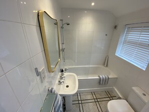 A modern bathroom with a bathtub, a sink, and a toilet.