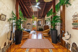 A hallway with a ceiling fan, potted plants, wicker furniture, and a patterned rug. - Holiday Home "Bernarda" with Heated Pool, Sea Views, Private Pool and Wi-Fi (Villa de Arico)