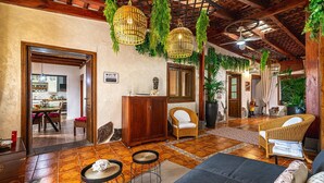 A spacious living area with a dining area, wicker furniture, and hanging plants. - Holiday Home "Bernarda" with Heated Pool, Sea Views, Private Pool and Wi-Fi (Villa de Arico)