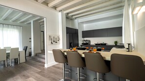 Une cuisine moderne dotée d’un îlot central, de tabourets de bar et d’un coin repas avec des chaises.