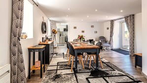Ein modernes Interieur mit Essbereich, Küche und Wohnbereich.