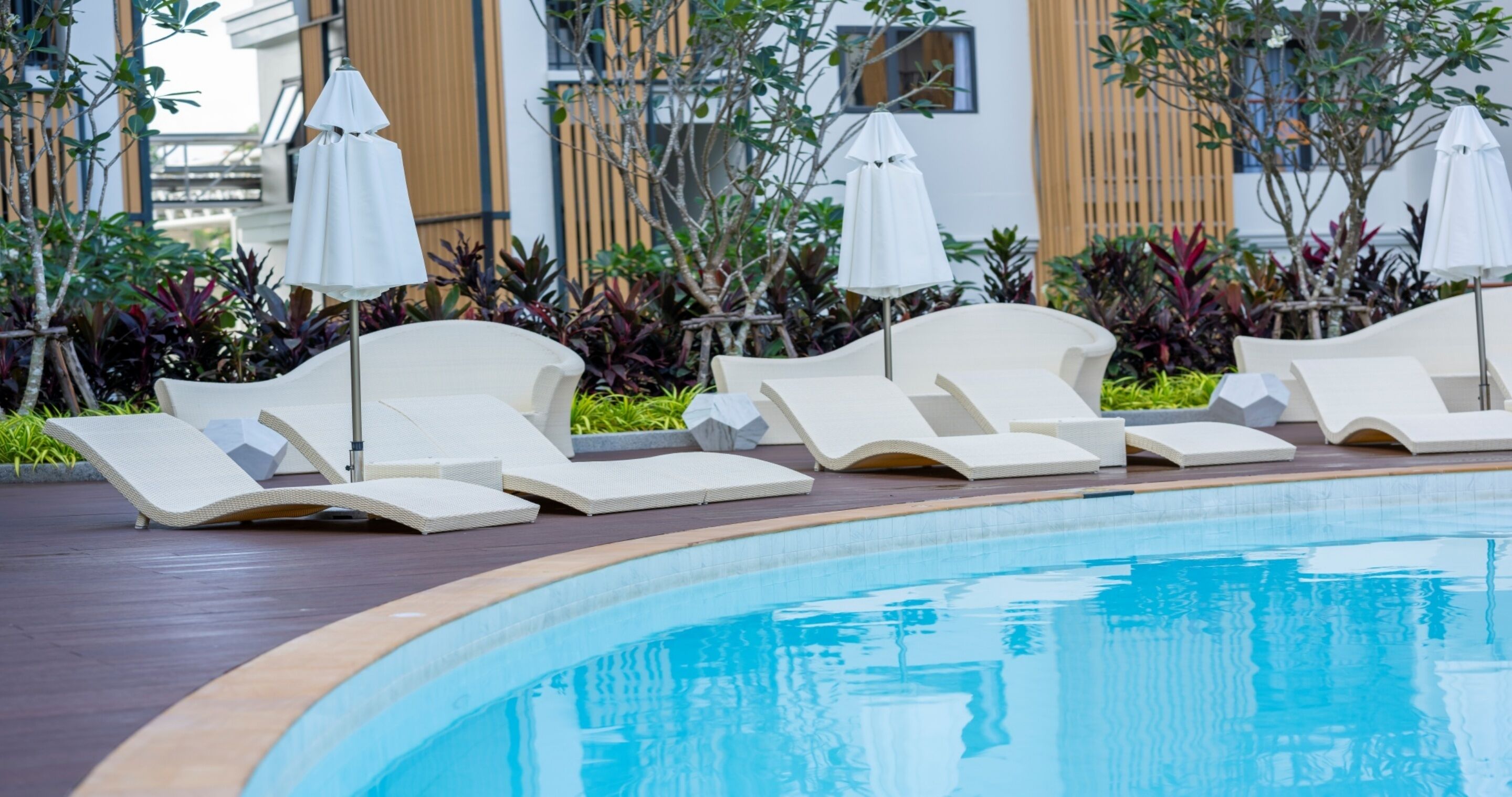 A poolside area with lounge chairs and umbrellas.