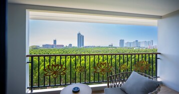 A balcony with a city view, a chair, and a small table.