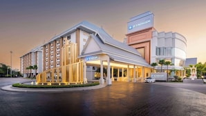 Un hotel Wyndham con diseño moderno, que cuenta con una entrada destacada, un paseo techado y un área de estacionamiento.