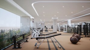 Un gimnasio moderno con equipo de ejercicio variado, un espejo grande y vistas al verdor a través de un muro de cristal.