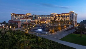 Um hotel grande com vários edifícios, área de estacionamento e jardins bem cuidados.