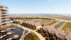 Resort com várias construções semelhantes a bangalôs, piscina e vista para a praia.