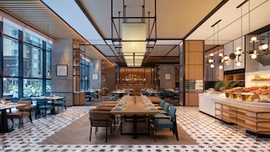 A modern dining area with a long table, multiple chairs, and a buffet counter. - Sheraton Taiyuan (Taiyuan)