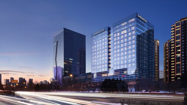 A Sheraton hotel with a modern glass facade, surrounded by other high-rise buildings and a busy road with light trails. - Sheraton Taiyuan (Taiyuan)