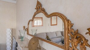 A marble countertop with a large ornate mirror, a small round table, and a stack of white objects. - Apartments Florence- Golden Tower with View (firenze)