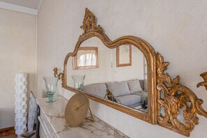 A marble countertop with a large ornate mirror, a small round table, and a stack of white objects. - Apartments Florence- Golden Tower with View (firenze)