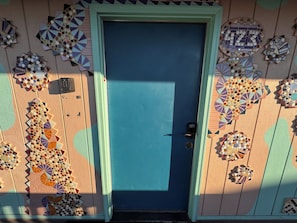 A blue door with a patterned wall and decorative tiles.