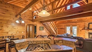 Een houten chalet van binnen met een keukenhoek, een eettafel en een gezellige zithoek.