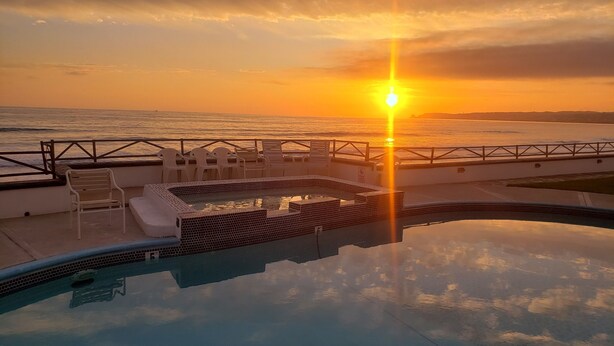 A pool area with a view of the sunset over the ocean, a lounge chair, and a small pool. - Olas ocean suite, pool, jacuzzi, bbq & terrace..Pet friendly, gated & secure (Primo Tapia)