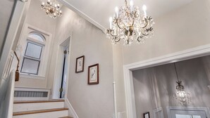 A staircase with wooden steps and white walls, leading to a door with a white frame. - Romantic Retreat with a Private Balcony! 3 Stories, 3 Bed 2 Bath, +FREE PARKING! (Denver)