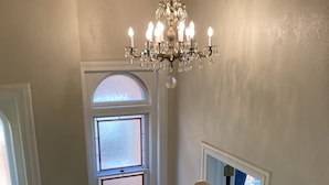 A staircase with a white railing, a chandelier, and a window with frosted glass. - Romantic Retreat with a Private Balcony! 3 Stories, 3 Bed 2 Bath, +FREE PARKING! (Denver)