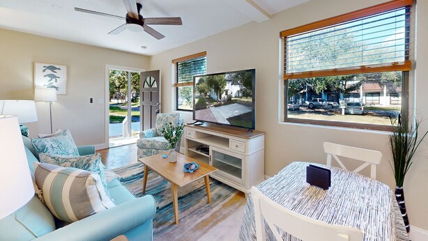 A living room with a sofa, coffee table, TV, and a window with blinds. - Newly remodeled house in San Marco few minutes walk to Square  & Riverwalk (Jacksonville)