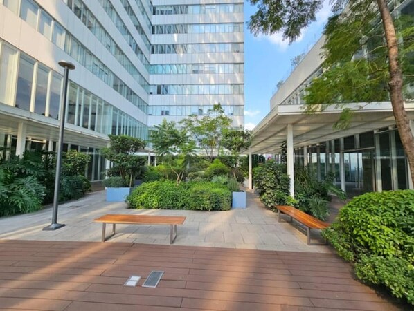 Relax in a serene outdoor space surrounded by lush greenery and seating areas.