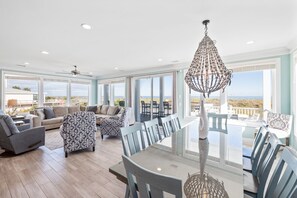 Relax in a spacious room with a dining table, comfortable seating area, and large window offering a view of the outdoors.