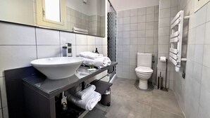 Ein modernes Badezimmer mit Waschbecken, Toilette und einer Duschkabine aus Glas.