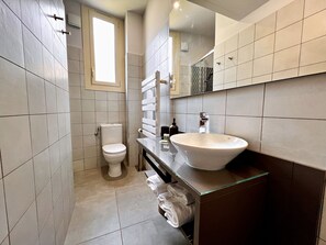 A modern bathroom with a toilet, sink, and mirror.