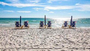 Une plage avec trois rangées de chaises longues disposées face à l’océan.