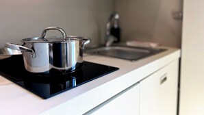 A kitchen with a stove top, a sink, and a cabinet. - MyResidenced'Azur Maison Micheloni apartment 10A (Beausoleil)