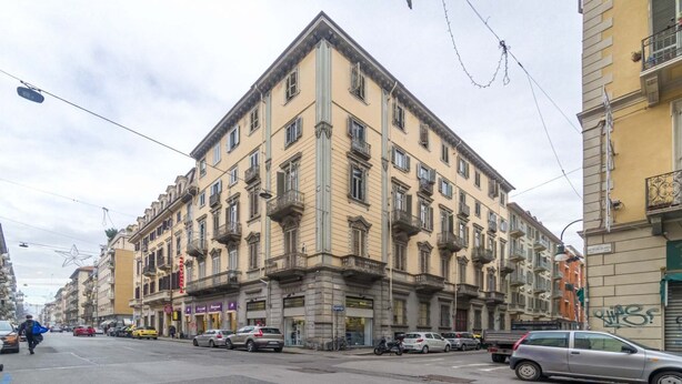 A multi-story building with a classic architectural style, featuring balconies and a ground-level entrance.