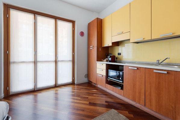 A kitchen with wooden cabinets, a built-in oven, and a sliding glass door.