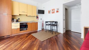 Une cuisine moderne avec des meubles en bois, un four à micro-ondes et un coin repas avec des chaises.